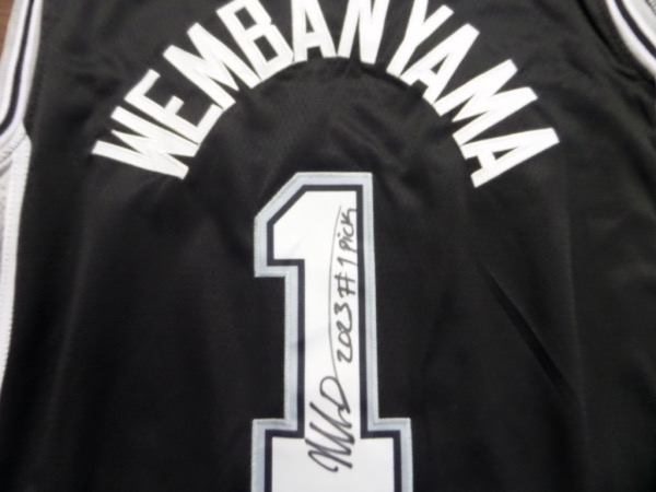 This is the one you've been waiting for!  It is a black size 50 San Antonio Spurs #1 Wembanyama jersey from Nike, still new with original tagging, and back number-signed in bold black sharpie by the highly-anticipated big man.  Signature grades an overall 8.5, complete with a 2023 #1 PICK inscription, and retail right now is actually into the thousands!