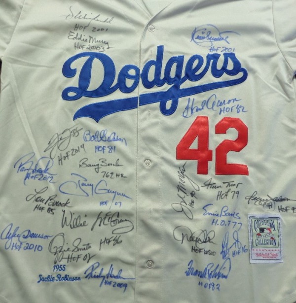 This cream colored size L 1955 Brooklyn Dodgers Jackie Robinson #42 throwback jersey from Mitchell & Ness is in NM/MT condition, and comes with everything professionally-sewn.  It is front-signed in blue or black sharpie by no less than 21 prominent black players/figures in baseball, all of whom would not be where they are without Jackie.  Included are Hank Aaron, Frank Robinson, Bob Gibson, Dave Winfield, Eddie Murray, Kirby Puckett, Frank Thomas, Barry Bonds, Tony Gwynn, Willie McCovey, Lou Brock, Andre Dawson, Ozzie Smith, Rickey Henderson, Barry Larkin, Willie Mays, Joe Morgan, Derek Jeter, Ken Griffey Jr, Ernie Banks and Reggie Jackson.  Many have provided inscriptions, and now, with NINE of these legends now deceased themselves, retail is well into the thousands on this baseball gem!