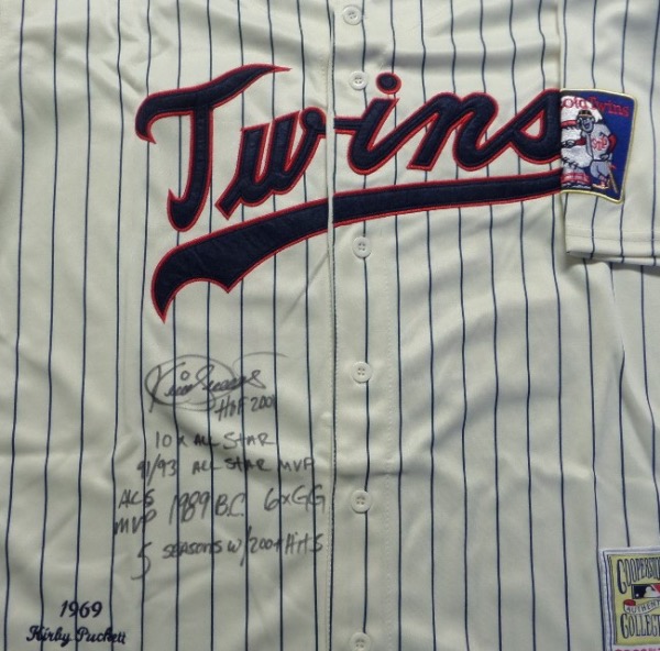 This pinstriped 1969 throwback Twins jersey from Mitchell & Ness is a size 44, like new, and trimmed in red and navy blue, with everything sewn.  It is front-signed in black sharpie by the HOF outfielder himself, grading a legible 8.5, with HOF 2001, 10X All Star, 91/93 All Star MVP, ALCS MVP, 1989 BC, 6X GG and 5 Seasons w/ 200+ Hits inscriptions.  With Puckett now gone nearly 20 years, retail on this collector's gem is low thousands!