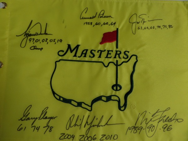 This MINT condition, authentic style yellow Masters pin flag features the Masters logo embroidered, and comes hand-signed all around in black sharpie by no less than SIX PGA greats who have won the famed Augusta major at least three times!  Included are Jack Nicklaus, Arnold Palmer, Gary Player, Tiger Woods, Nick Faldo, and Phil Mickelson, and each golfer has added the years that he won the tournament as an inscription.  NO golf collection would be complete without this crown jewel, valued into the low thousands!