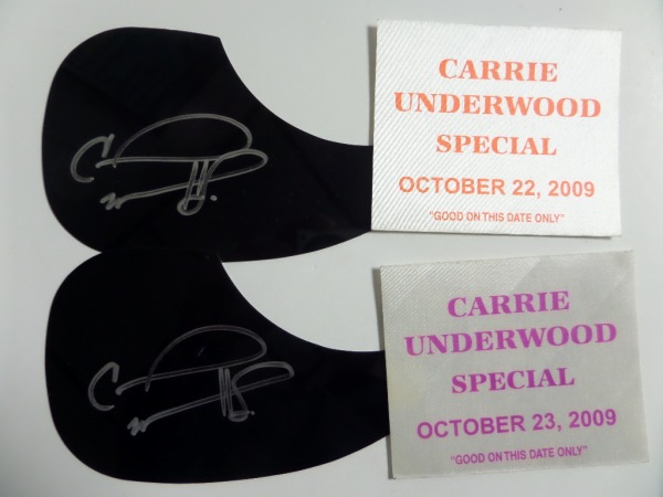This sky high retail opportunity is TWO black acoustic guitar pick guards, each hand-signed in silver by country music superstar, Carrie Underwood.  Each grades a legible 8 at least, and each included its own 2009 concert tour pass for provenance.  All you have to do is affix one of these babies to an acoustic guitar, and BAM!  Signed guitar!!!