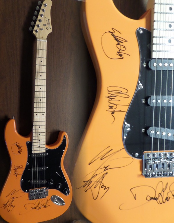 This mint, full-sized burnt orange-colored electric guitar is neat-looking with unique styling and comes hand signed by all 4 bandmates including lead guitarist and now deceased star Eddie Van Halen,Alex,Michael, and David Lee Roth!   It comes IN PERSON obtained, grades as good as it gets on the mint guitar, and shows off well from 30+ feet away. Great musical investment in the well known Rock N Roll group, and is complete with Lee's own lifetime guarantee included and original carry bag,etc.. WOW!
