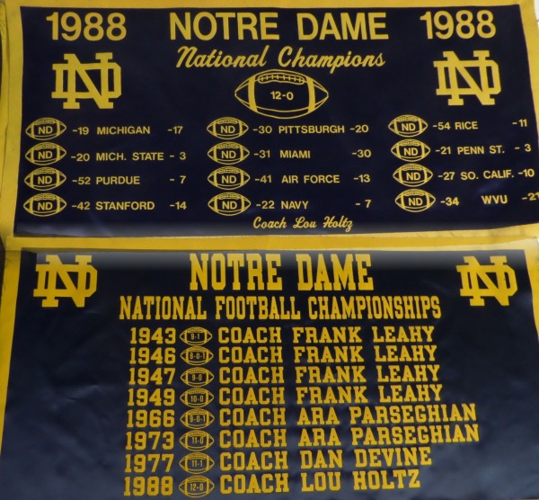 This outstanding and one of a kind--actually, TWO of a kind--lot is TWO different gold and blue 18x30 banners, each constructed of silk and felt, and each in EX/MT or better condition.  One commemorates the 1988 National Championship season, with results of games listed, and the other lists all National Championships from 1943-1988.  Notre Dame fans are, in a word, rabid, and this lot is, in two words, highly desirable!!!