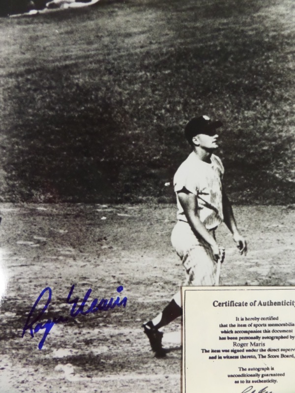 This black and white 8x10 photo is an image of Roger Maris watching the flight of his 61st and record-setting HR off of Tracy Stallard at the end of the memorable 1961 season.  The photo is hand-signed in blue sharpie by the 2 time AL MVP himself, and is fully certified by The Score Board for rock solid authenticity.  Valued into the very high hundreds!