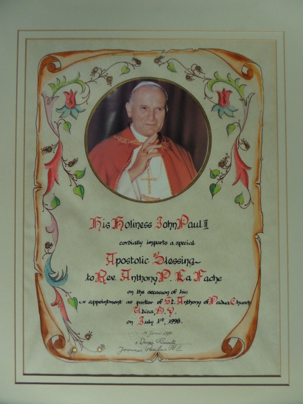 This large 18.5x22.5 custom double white-matted display houses a commemoration of a 1998 Apostolic blessing from Pope John Paul II to a reverend in Utica, New York.  A color photo is affixed, but the writing is all by hand, including a black ink signature from the Pope at the bottom, reading his Latin name of Joannes Paulus PPII.  AWESOME piece, and a true collector's item for Catholics everywhere!