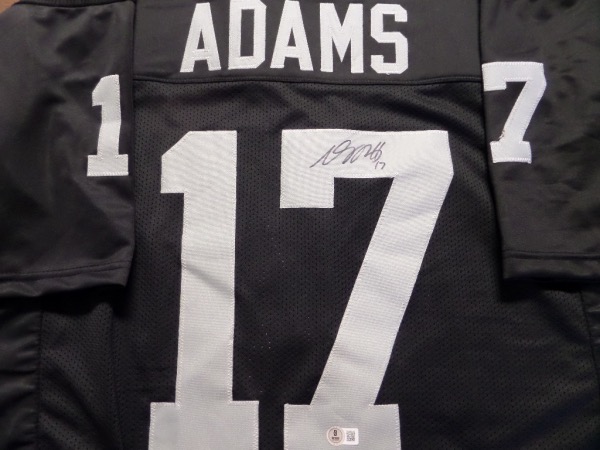 This black custom XL Vegas Raiders #17 Adams jersey is like new, and comes with everything sewn in silver.  It is back number-signed in black sharpie by the six time Pro Bowl receiver himself, grading a legible 8.5 at least, and is affixed with a Beckett Witness hologram (1W398146) for absolute authenticity.  A great looking jersey, valued into the high hundreds!