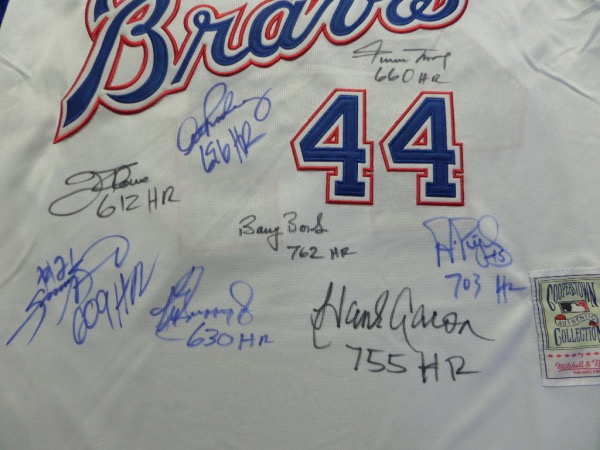 This white #44 Hank Aaron 1974 throwback Braves jersey from Mitchell & Ness is in NM/MT condition, a size L, with everything sewn.  It is hand-signed on the front in blue and black sharpie by 8 of the 9 members of the RARE 600 Home Run Club, including Aaron, Griffey Jr, Thome, Mays, Sosa, Bonds, Pujols and ARod.  Awesome looking jersey, a MUST for framing and display, and retail is thousands!