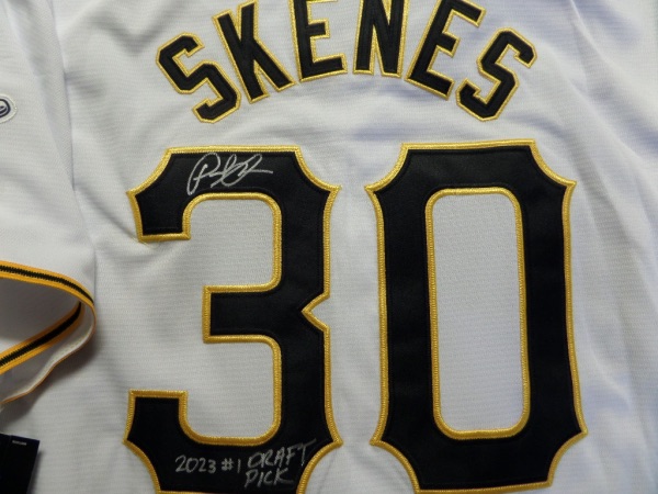 This home white size L Pittsburgh Pirates #30 Skenes jersey from Nike is still tagged as new, and has everything sewn in black and gold.  It is back number-signed by the star rookie hurler himself, grading a legible 8.5, and includes a 2023 #1 Draft Pick inscription to boot.  This is the first Skenes jersey we've featured here at CCSA, and is smoking hot on the retail circuit right now!