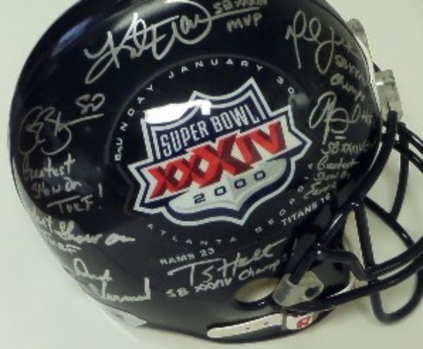 This Super Bowl XXXIV logo navy blue full size football helmet from Riddell is still in NM condition, and comes hand-signed in bright silver by 6 members of the Champion Rams team.  Included are future HOF'er Torry Holt, as well as established HOF'ers Orlando Pace, Isaac Bruce, Kurt Warner, Marshall Faulk and coach Dick Vermeil, and with all six autographs present, this wonderful collector's item is valued into the low thousands!