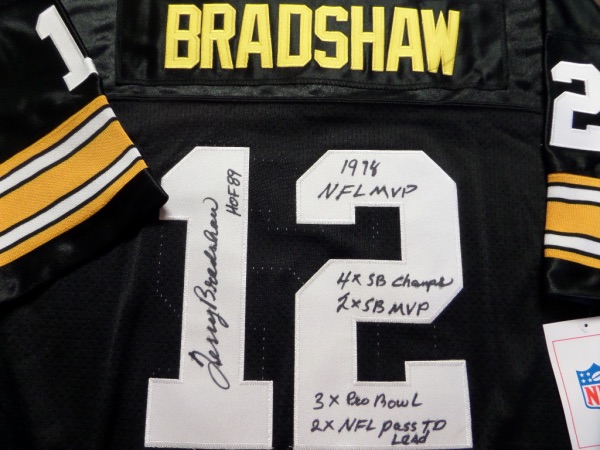 This black size 50 M&N Pittsburgh Steelers 1982 Bradshaw #12 football jersey is still tagged as new, and comes trimmed in yellow and white, with everything sewn, including original manufacturer's tagging.  It is back number-signed in black sharpie by the HOF passer himself, grading an overall 8.5-9 and including HOF 89, 1978 NFL MVP, 4X SB Champs and 2X SB MVP, 3X Pro Bowl and 2X NFL Pass TD Lead inscriptions.  A fantastic Steelers collector's item, and retail is into the very high hundreds!