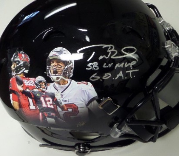 This authentic game style black football helmet is in NM condition, with full face mask, visor, and three different Tom Brady Buccaneers triple images on either side.  It is hand-signed in silver by the man himself, grading a legible 8-8.5, with SB LV MVP and G.O.A.T. inscriptions, and retail on this Bucs GEM is low thousands!