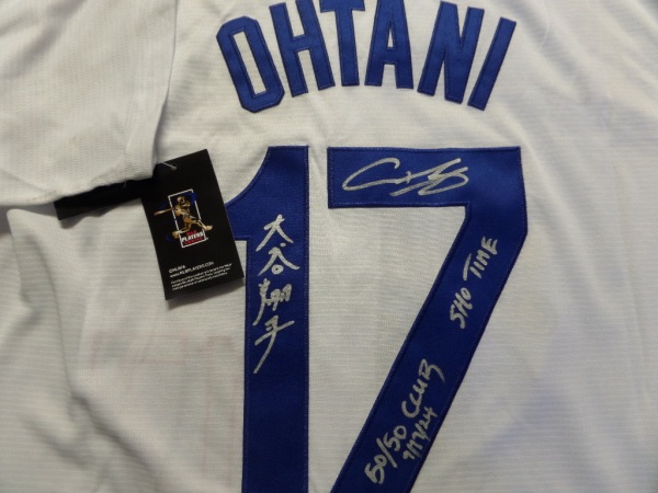 This white size L custom #17 Dodgers Ohtani jersey is still tagged as new, and comes trimmed in royal blue, with everything hand-sewn.  It is back number-signed in bright silver by the 2 time AL MVP himself, written in both English and Japanese, and even a SHO TIME inscription, grading an 8.5 at least.  This jersey also has a BRAND NEW inscription, reading 50/50 CLUB 9/17/24!!!  A great looking jersey, and retail is THOUSANDS right now at least!