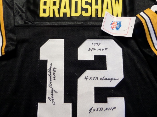 This black size 50 M&N Pittsburgh Steelers 1982 Bradshaw #12 football jersey is still tagged as new, and comes trimmed in yellow and white, with everything sewn, including original manufacturer's tagging.  It is back number-signed in black sharpie by the HOF passer himself, grading an overall 8.5-9 and including HOF 89, 1978 NFL MVP, 4X SB Champs and 2X SB MVP inscriptions.  A fantastic Steelers collector's item, and retail is into the very high hundreds!