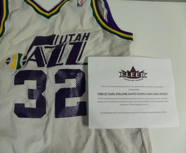 This well used Utah home white is colorfully trimmed, has the exclusive Sand-Knit team tag still intact in the waist, and has a full LOA included from Fleer. Portions of the jersey have been removed to be placed in GU cards, and it was used by the HOF Great during the 1986-87 season. Great buy, about 92% still here and intact, and missing the rear nameplate. 