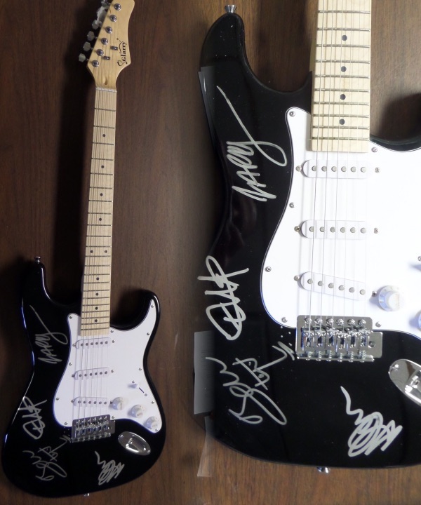 This black "strat style" electric guitar comes silver paint pen signed by all four band members, including Bono--with an added self sketch--Edge, Larry and Adam!!  An amazing, "Hard Rock Cafe" style display item that will shine in any rock music collection, and retail potential here is into the low thousands!