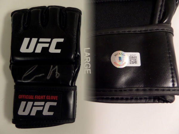 This NM black UFC fight glove comes hand-signed in silver sharpie by one of the most flamboyant fighters in the history of the sport, Conor McGregor!  The signature grades about a 7, and the glove is affixed with a hologram from Beckett Authenticated (BJ57477) for your certainty.  Valued into the mid/high hundreds!