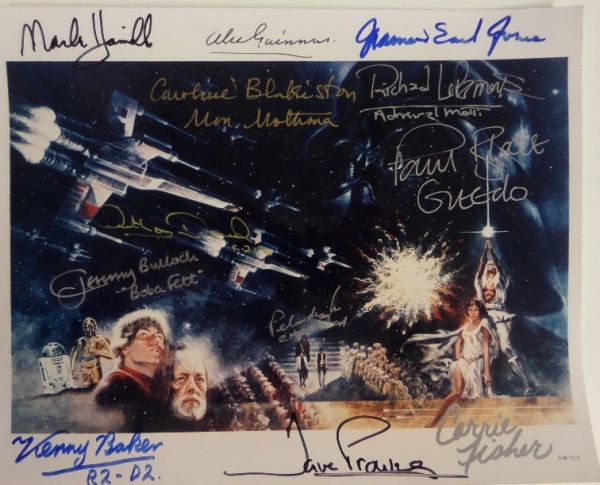 This color 8x10 is a print from an original 1970's poster, and shows a number of images from the hit 1977 film, "Star Wars."  It comes hand-signed by no less than 11 participants of the original franchise, including both stars and side characters.  Herein, in gold, silver, black and blue, are mainstays Carrie Fisher, David Prowse, Kenny Baker, Anthony Daniels, Peter Mayhew, Mark Hamill, Alec Guinness, and James Earl Jones, but also Richard LaParmentier, Jeremy Bulloch, Paul Blake and Caroline Blakiston, all of whom have included their character's name as an inscription.  With 7 of the 11 people on here now deceased, this frame-ready 8x10 is valued into the high hundreds/low thousands!