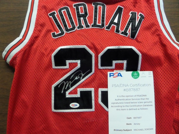 This 1990's Chicago road red is trimmed in black and white team colors, has sewn on everything as well as name on back, and comes back #23 signed by the GOAT in bold silver paint pen. The REAL PSA/DNA lifetime hologram remains, as does the online report from PSA/DNA, and value is 4 grand all day long! 