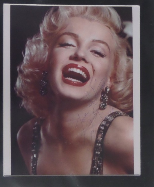 This 10x12 matted piece houses a full color close up photo of Hollywood legend, Marilyn Monroe.  It is hand-signed in blue ink by the icon herself, complete with her standard Love and Kisses inscription, and, with her untimely death now 63 years ago, this frame-ready matted display is valued into the low thousands!
