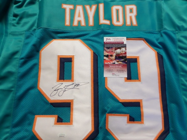 This aqua custom Miami Dolphins #99 Taylor jersey is trimmed in white, orange and navy, and has everything hand-sewn.  It is back number-signed in black sharpie by the former NFL Sack leader himself, and comes fully JSA certified (WPP516982) for authenticity purposes.  Valued well into the hundreds!
