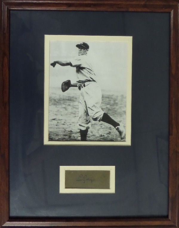 This 16x20 wood-framed and white and blue double-matted display houses a black and white photo of The Iron Horse, Lou Gehrig, throwing a ball from first base in his home white NYY pinstripes!  Beneath this photo is a cut of dark colored paper, hand-signed in black fountain pen ink by the HOF'er, Triple Crown winner, 2 time AL MVP and record-setting ironman himself!  The signature grades about a 6, and this display-ready framed piece values well into the low thousands!