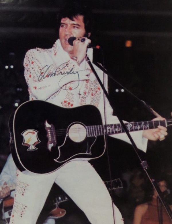 This full color 8x10 is done on a thinner stock than regular photo stock, is in EX shape, and shows a color image of Elvis in the 1970's, playing guitar--well, holding a guitar--live in concert.  It is very nicely-penned in black felt tip marker by "The King" himself, and grades about an 8.  Ready to frame and display, and, with Elvis' death approaching a half century ago now, retail is low thousands, to be certain!