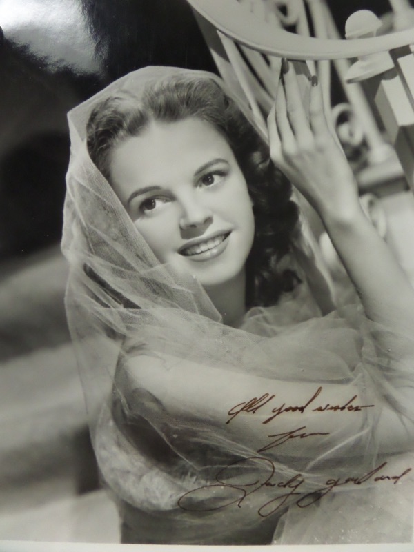 This stunning piece of Hollywood history is a vintage black and white publicity 8x10 photo of a very young Judy Garland, probably a 1940's image.  It is hand-signed in flair pen which appears brown, and the signature grades a strong 8 at least, with an All Good Wishes From inscription.  This gorgeous photo will frame and display to the delight of all, and really enhance any silver screen collection in the world!  Valued into the low thousands!