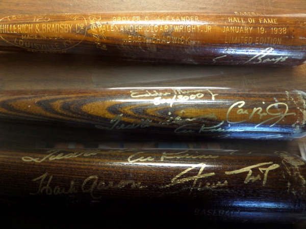 This dark brown Louisville Slugger 125 bat is in EX/MT shape, and comes barrel-engraved in GOLD to commemorate the 1938 HOF Induction which welcomed Grover Alexander, Henry Chadwick and Alexander Cartwright to the Hall.  It is hand-signed, also in gold, by 7 HOF greats who are either in the 500 HR Club or the 3000 Hit Club ... or both, and included are Willie Mays, Hank Aaron, Eddie Murray, Ernie Banks, Cal Ripken Jr., Ted Williams and Al Kaline.  With FIVE of these all time greats not longer with us, retail is low THOUSANDS on this beautiful bat!