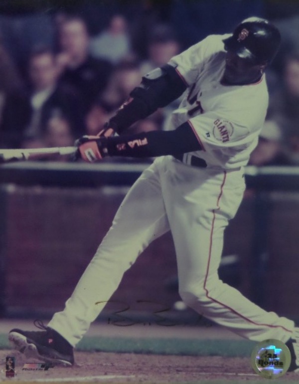 This full color 8x10 photo shows Barry Bonds connecting on what was most likely one of his 762 lifetime home runs.  It is hand-signed in black felt tip marker by the 7 time NL MVP himself, and the signature grades about a 7 overall.  The photo is affixed with a 25 Barry Bonds Authenticated hologram for certainty, and retail is mid hundreds!
