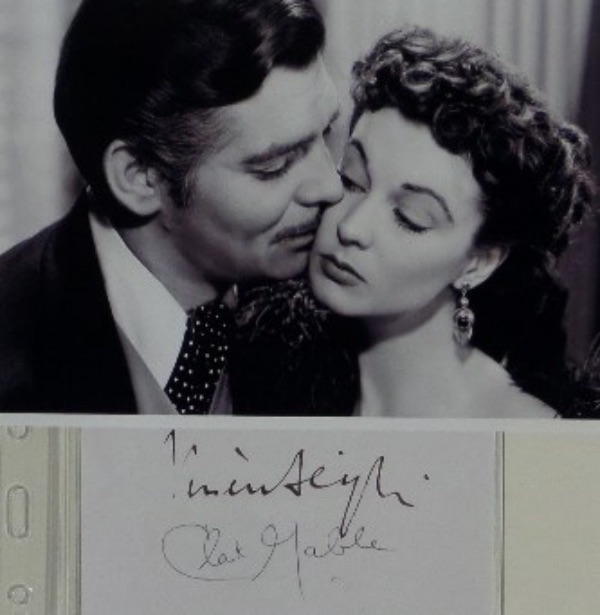 This fantastic Hollywood collectors item is a vintage cut of white paper, measuring a sizeable 2.75x4.75, in NM condition, and hand-signed by the screen duo of Clark Gable and Vivien Leigh.  Leigh's brown fountain pen ink signature grades a strong 7, and Gable's black ink signature grades about a 6, and the cuts come with a black and white "Gone With The Wind" photo for display!