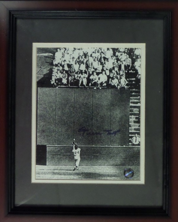 This 13x16 custom framed and double matted display houses a black and white photo.  It is the iconic image of Willie chasing down Vic Wertz's deep fly ball in the 1954 World Series before "magically" hauling it in, and it comes hand-signed in blue sharpie by the Giants HOF great himself.  A hologram has been affixed from Mays' own Say Hey company, and this display-ready piece is valued into the mid/high hundreds!