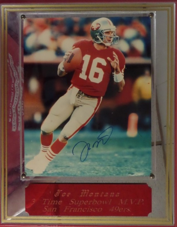 49'ers fans, this piece is literally MADE for your collection!  It is a 12x15 plaque, 49'ers RED on the outside with a mirror and a color 8x10 of Montana in action.  The photo is hand-signed in blue felt tip marker by the 4 time SB Champion QB, and the piece is fully JSA certified (Y63873) by JSA for authenticity purposes.  Valued into the low thousands!