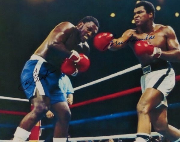 This full color 8x10 shows an image from the famed 1975 final chapter in the Ali/Frazier trilogy!  It is hand-signed by BOTH all time great Heavyweight Champions, with Frazier in black sharpie and Ali in blue, and will frame and display exquisitely for your boxing collection.  With both men now deceased, retail is high hundreds!
