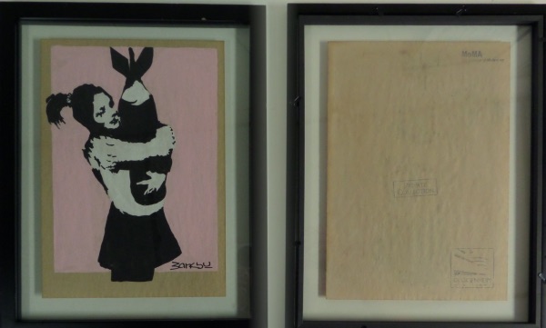 This stellar work comes with lots or provenance on the back side, is framed in black wood, and shows a girl holding a nuclear missle. Neat piece, high value obviously, and with lots of black, white and pink colors in it. 