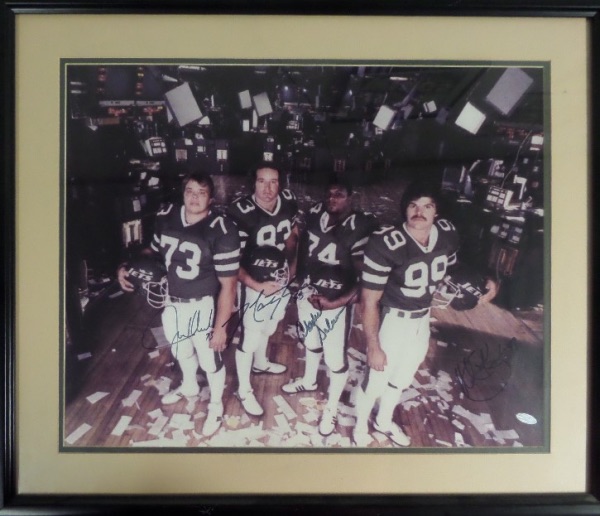 This 22x25 black framed and tan/green double matted display houses a large, full color photo of the 1980's New York Jets defensive line standing in the "pits" of Wall Street.  It comes hand-signed in blue felt tip marker by all four members of the vaunted D Line, including Gastineau, Salaam, Lyons and Klecko, and also includes a hologram from Steiner Sports Memorabilia for authenticity purposes.  Ready for display and valued into the very high hundreds!
